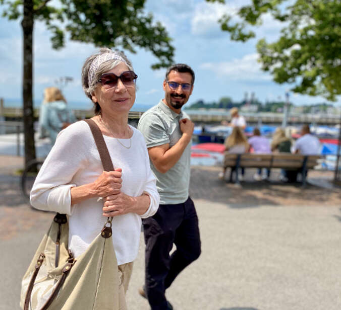 Zwei Menschen gehen an Promenade spazieren