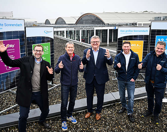 Fünf Münner stehen auf dem Dach der Messe