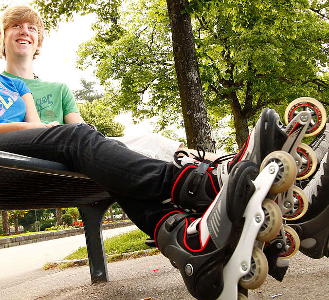 Zwei junge Skater sitzen auf einer Bank