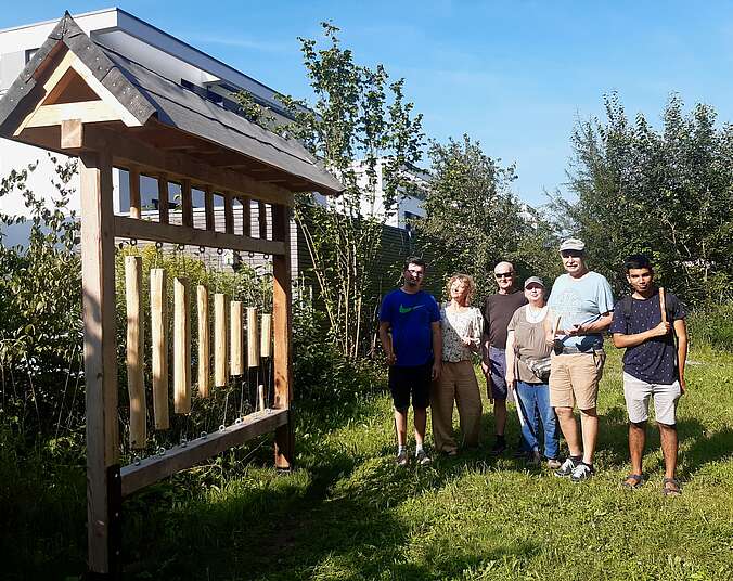 Sechs Personen präsentieren Klangspiel aus Holz