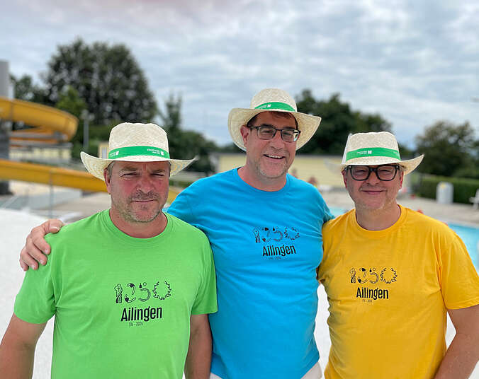 Drei Männer in farbigen Shirts mit Logo 1250 Jahre Ailingen