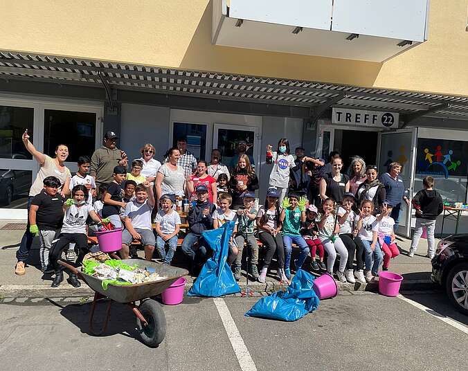 Gruppe Menschen mit Schubkarre vor einem Familientreff